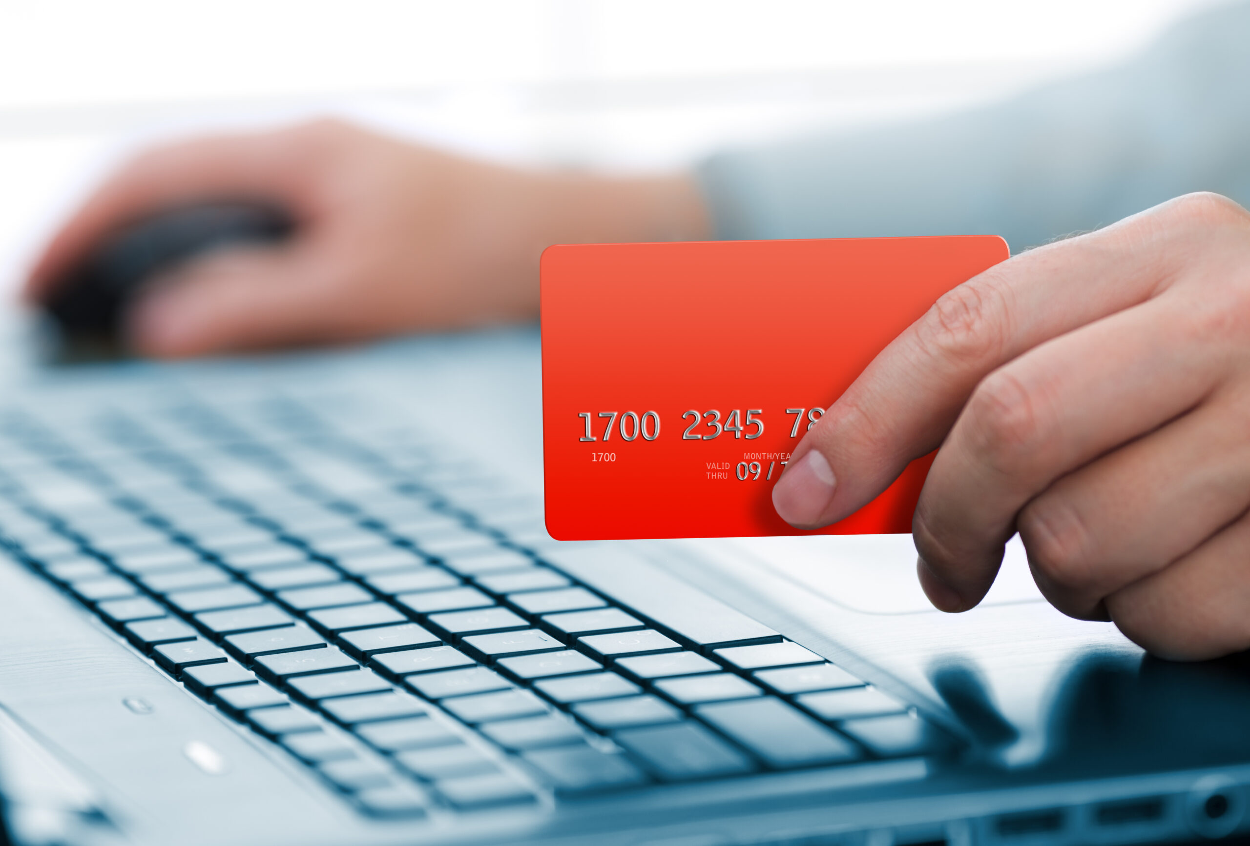 Man,holding,credit,card,in,hand,and,entering,security,code