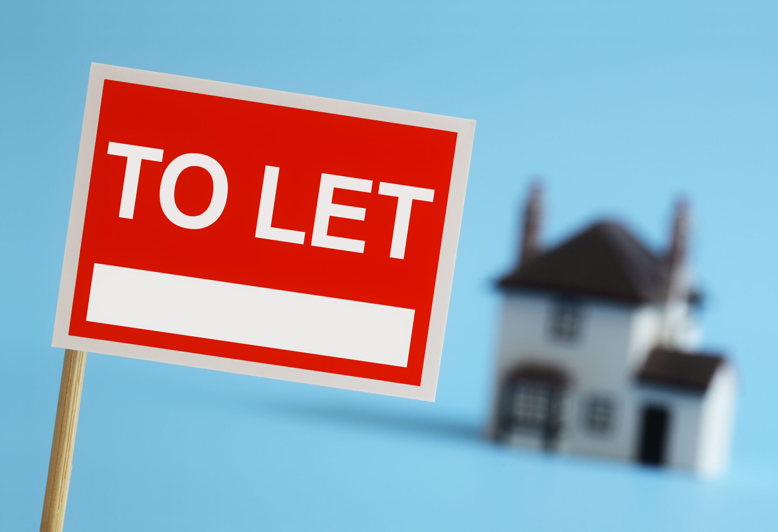 Real,estate,agent,to,let,sign,with,house,in,background