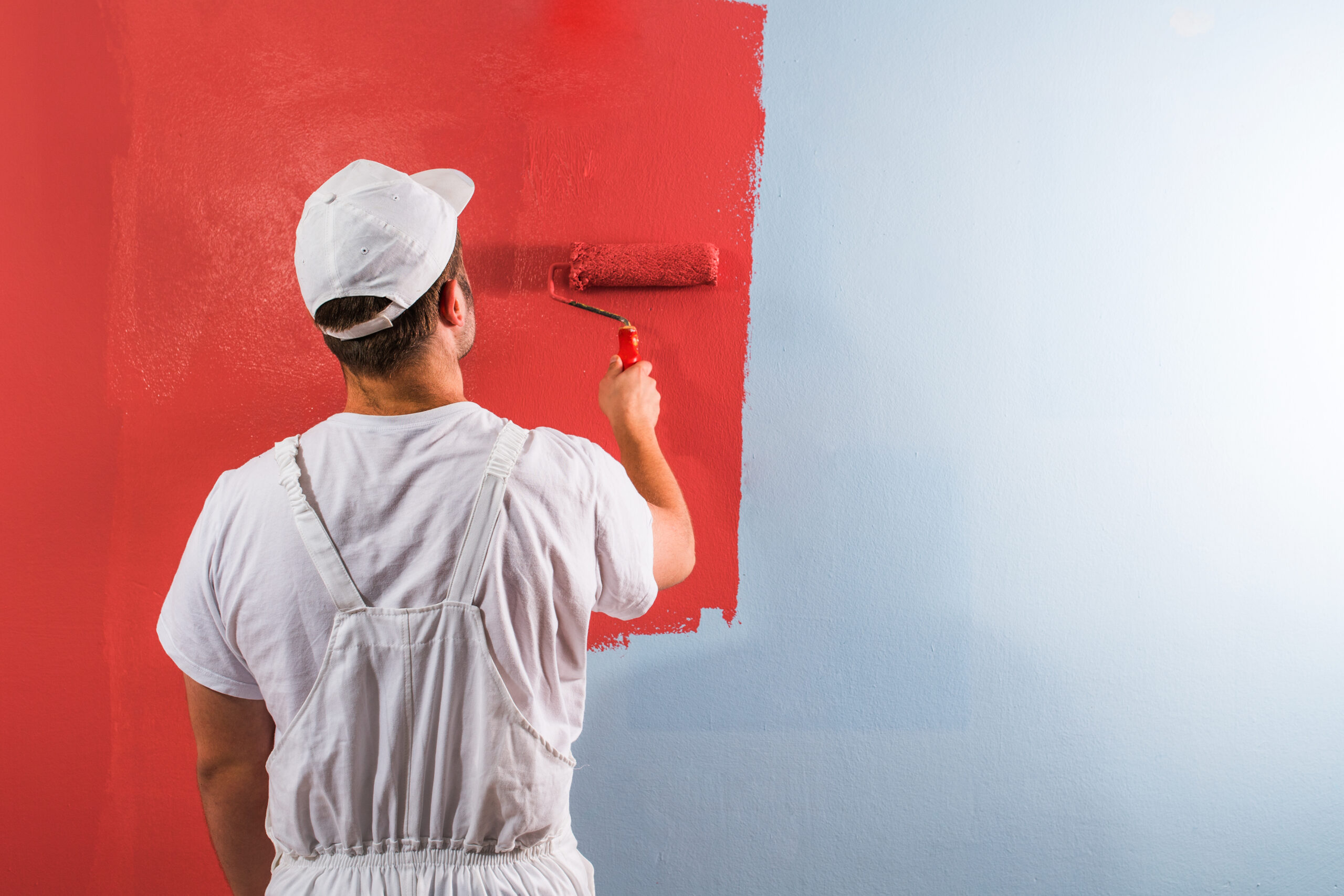 Young,man,painting,wall,with,roller