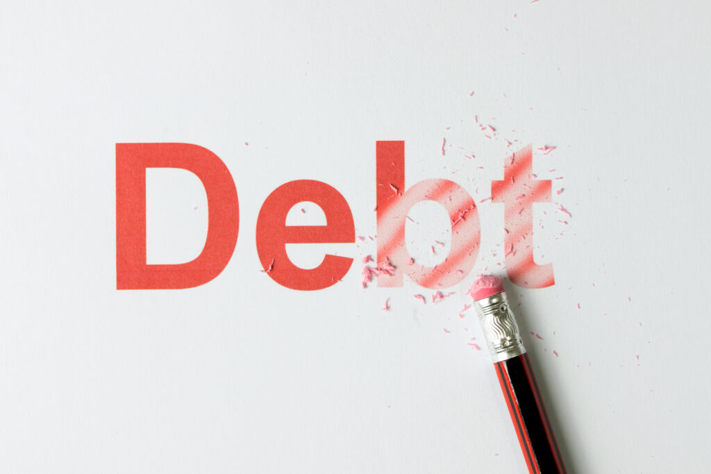 Close,up,of,red,pencil,erasing,the,word,debt,on